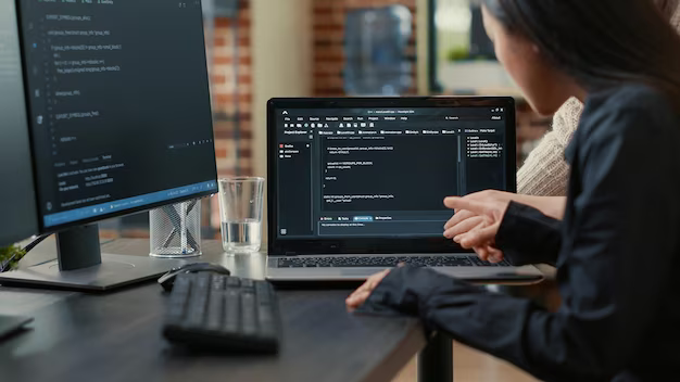 A team of programmers talking about an algorithm running on a laptop screen