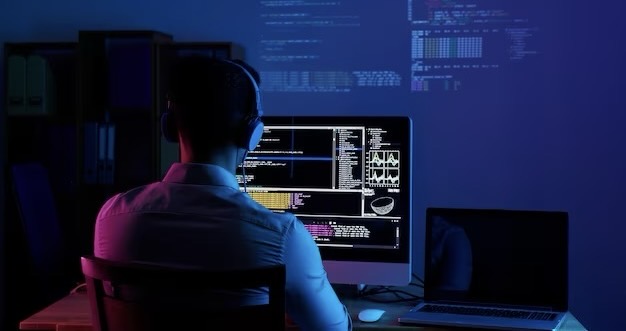 Rear view of programmer working at night